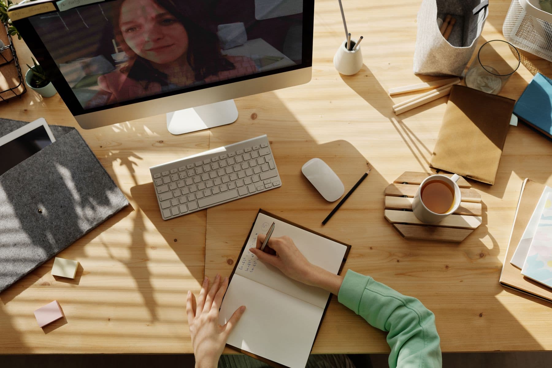 Persona estudiando con un Mac mientras toma apuntes